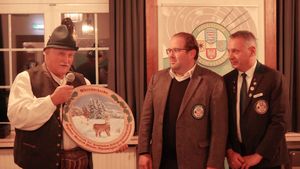 Manfred Winter (links) übergibt die Ehrenscheibe an Florian Keil, den Gewinner des Ehrenscheibenschießens 2025. Ganz rechts: HSV-Vizepräsident Thomas Scholl. (Foto: Lutz Berger)