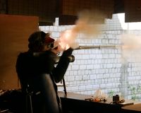 Ein Vorderladerschütze im sportlichen Wettkampf. Man sieht das Pulverfeuer am Hahn und an der Mündung des Laufes.