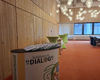 Blick in einen Raum mit einer Theke, auf der Logo des Projekts "Schützen im Dialog" zu sehen ist.