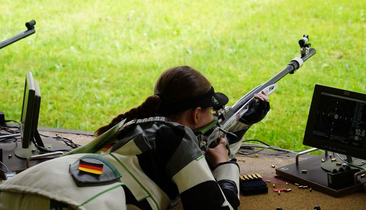 Eine Sportschützin im Liegendanschlag mit einem KK-Gewehr von schräg hinten gesehen. (Foto:DSB)