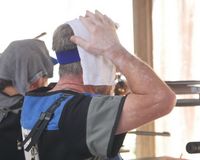 ein Sportschütze, der versucht, sich mit einem feuchten Tuch auf dem Kopf abzukühlen. (Foto: Lutz Berger)